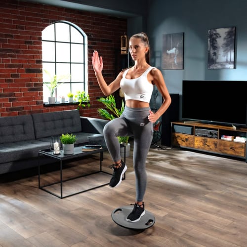 Eine Frau trainiert auf einem Balance-Board