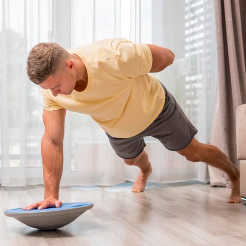 Ein Mann trainiert auf einem Balance-Board